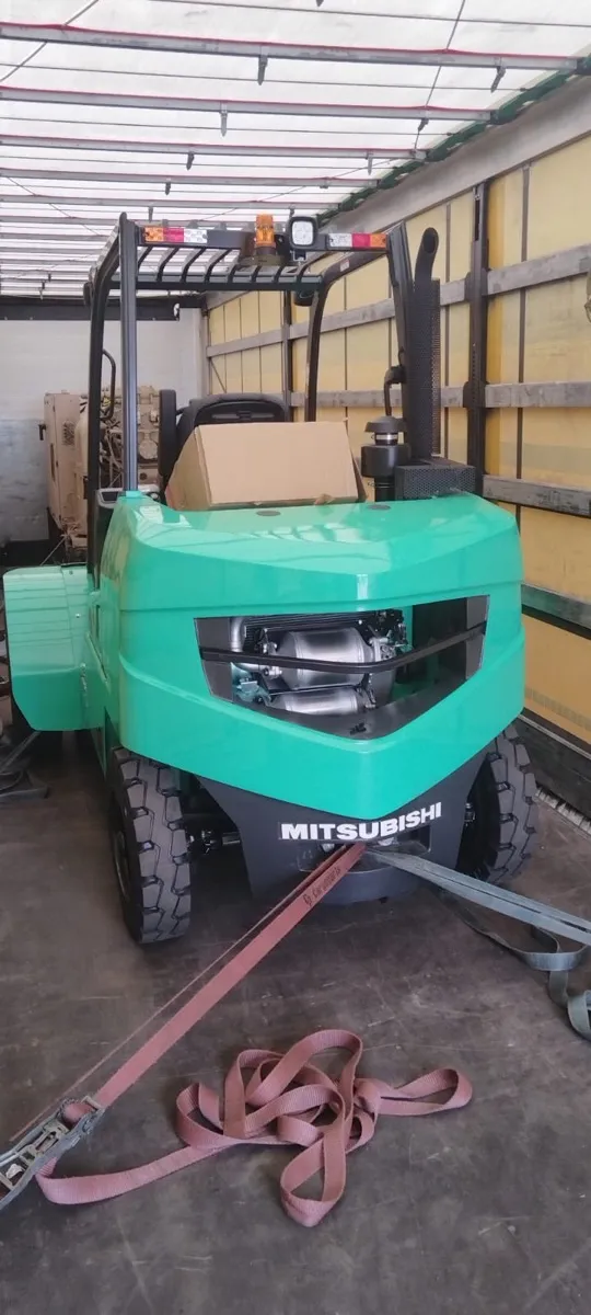Wózek widłowy Mitsubishi zabezpieczony pasami w naczepie