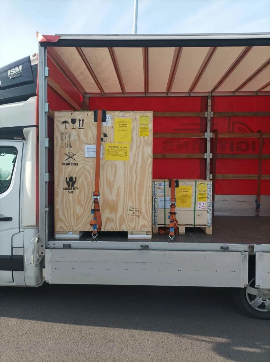 Zabezpieczony ładunek w skrzyniach drewnianych w naczepie transportowej